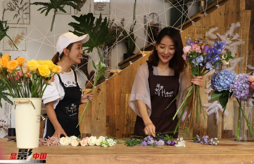 “昆明是鮮花的原產(chǎn)地，有亞洲最大的鮮切花交易市場，可以說具備開花店的天時地利；另外和很多女孩一樣，我從小也就有開花店的夢想！”說起當(dāng)初的決定，王黎媛說一是因?yàn)閴粝?，另外也跟昆明這個城市產(chǎn)花、賣花的“基因”有關(guān)。圖為王黎媛和同事在制作花束。新華網(wǎng) 周亞平/攝 念新洪/文